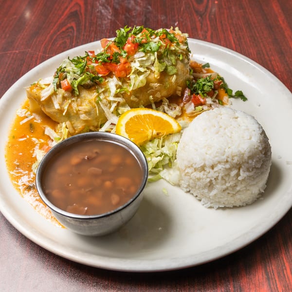 Golden chimichanga topped with lettuce and pico de gallo, served with white rice and pinto beans.