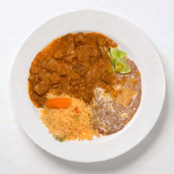 A plate of Mexican food with stewed pork, rice, refried beans, and lime wedges.