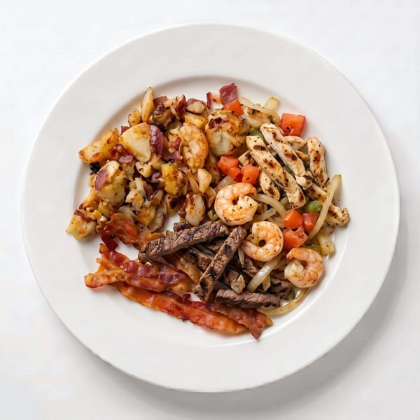 A white plate with a hearty breakfast of bacon, shrimp, steak, chicken, and potatoes.
