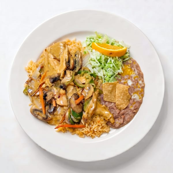 Chicken with mushrooms and vegetables in a creamy sauce, served with rice, refried beans, and shredded lettuce.